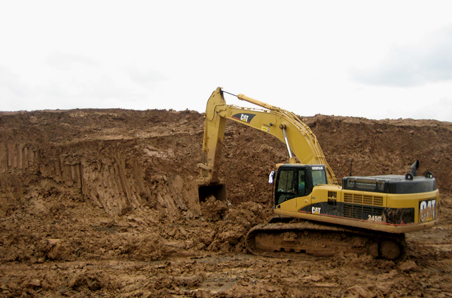 Caterpillar excavator grading fill on a Great Bear Construction earthwork site in Texas